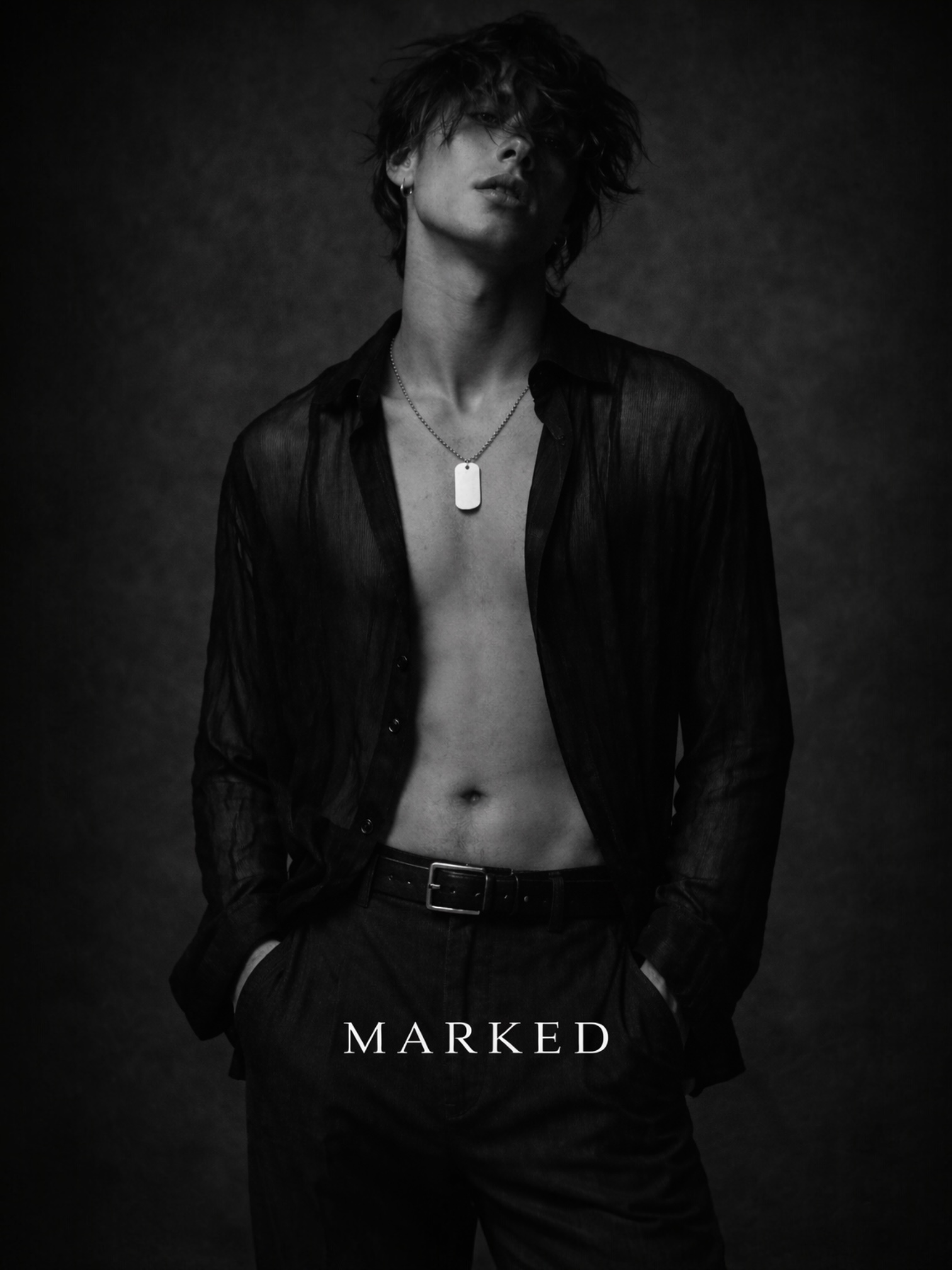 Androgynous male model in open sheer shirt wearing a dog tag pendant, black and white editorial image exploring identity and control – MARKED jewellery