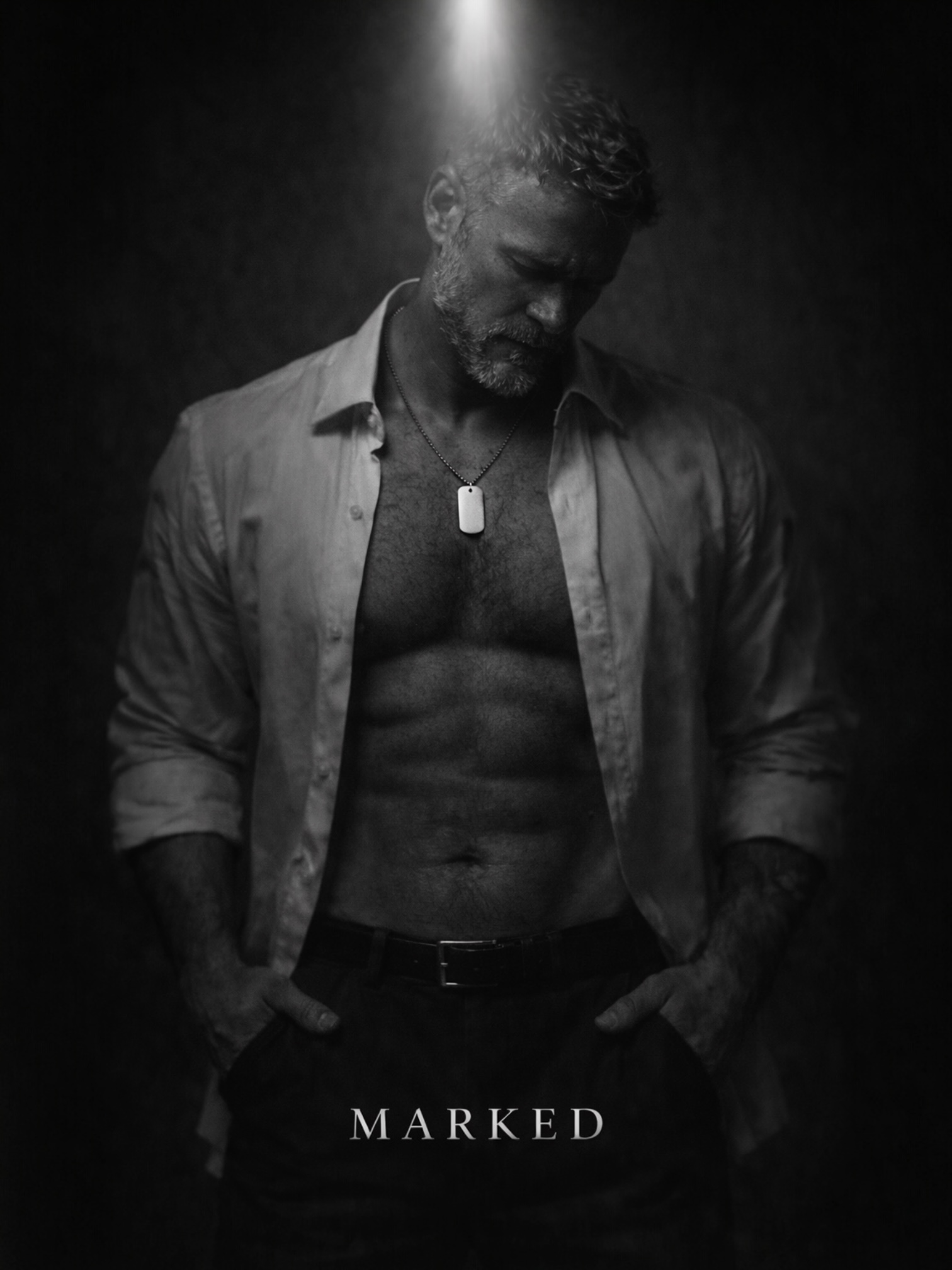 Black and white portrait of man under overhead light wearing a dog tag pendant, symbolising surrender, reflection and identity – MARKED jewellery