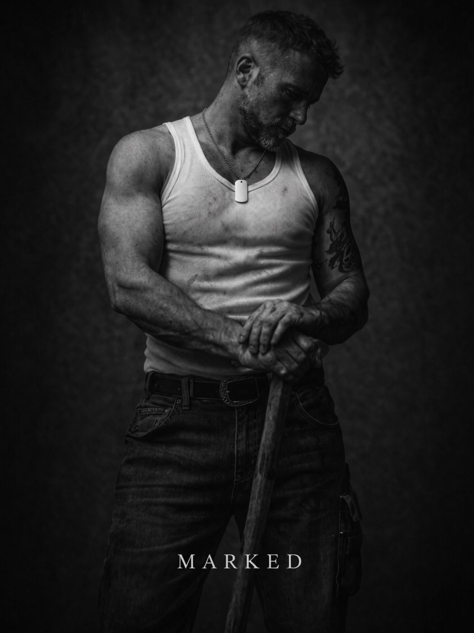 Muscular man in white tank top holding tool, wearing a dog tag pendant, black and white image symbolising physical strength and labour – MARKED jewellery